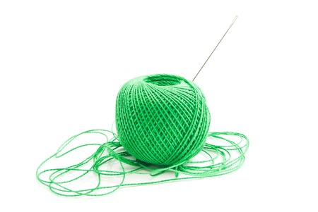 spool of green thread and needle on whiteの写真素材