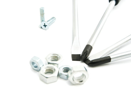 screwdrivers and various nuts on white background