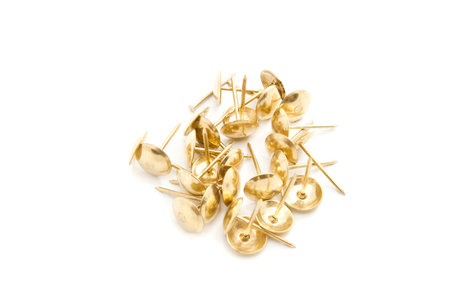 heap of golden pins closeup on white background