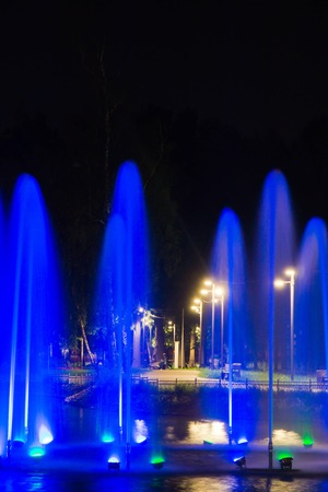 fountain with blue backlight in night parkの写真素材