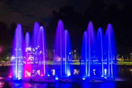 Fountain with backlight on the pond in night parkの写真素材