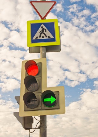 traffic light and road signs against the sky and cloudsの写真素材
