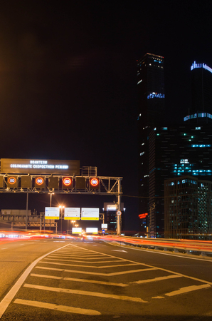 traffic in city center at night and skyscrapersの写真素材