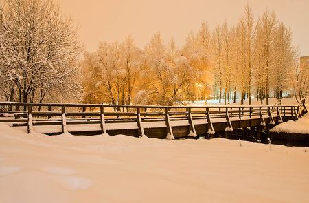 wooden bridge in the winter city park in the eveningの写真素材