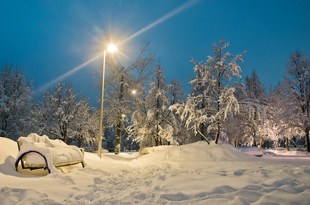 street lamp and bench in evening winter parkの写真素材