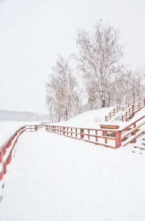 wooden fence in the city park in winterの写真素材