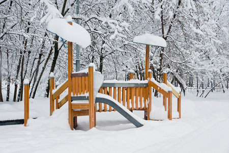 snow covered childrens slide in the parkの写真素材