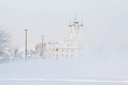 church and trees in the snow in winterの写真素材