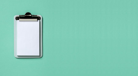 Clipboard on turquoise horizontal background. Flat lay, top view trendy for banner