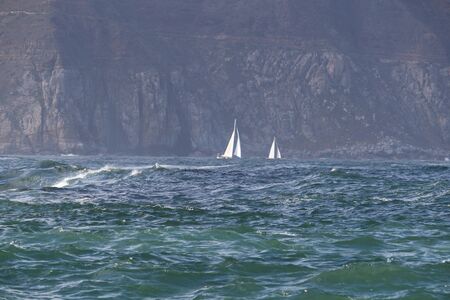 Two white yachts sailboats in the seaの写真素材