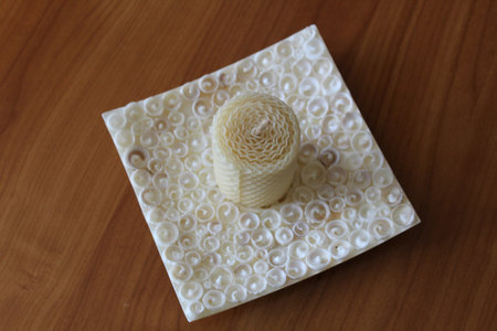 White candle without flame on the plate made of seashellsの写真素材