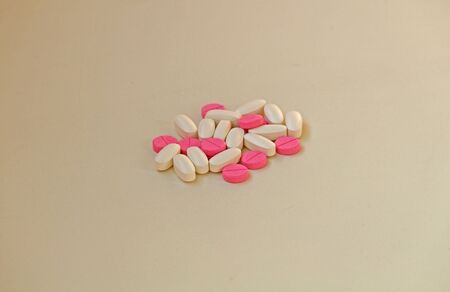 White and rose tablets pills on white backgroundの写真素材