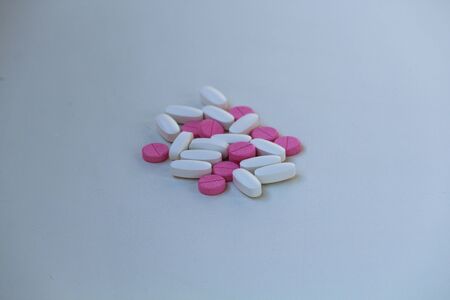 White and rose tablets pills on white backgroundの写真素材