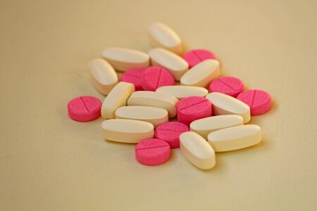 White and rose tablets pills on white backgroundの写真素材