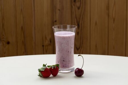 One glass of strawberry smoothie milkshake with strawberry on white tableの写真素材