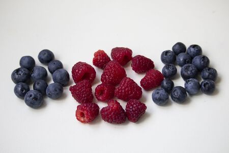 blueberries and raspberries on white background flat layの写真素材