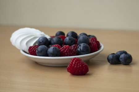 fresh blueberries and raspberries in a bowl with marshmallowの写真素材