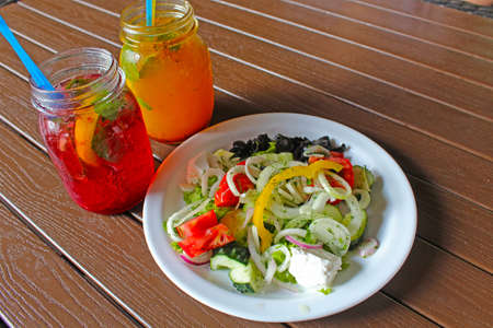 Greek salad with fruit drinks lunchの写真素材