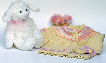 Yellow and pink hand knit baby sweater with elephant buttons, matching tea bag hat, and white...