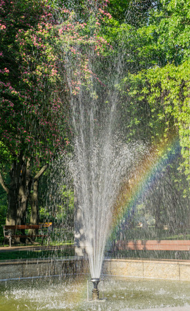 Fountain with rainbow in public parkの写真素材