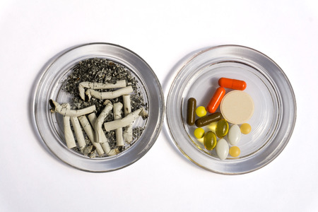 Cigarette butts and pillsの写真素材