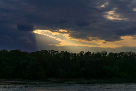 Cloudy dramatic sunset over water, river, lakeの写真素材