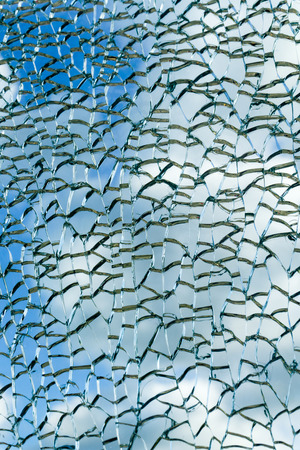 Cloudy sky view through broken glass. Broken glass texture. Abstract background.の写真素材