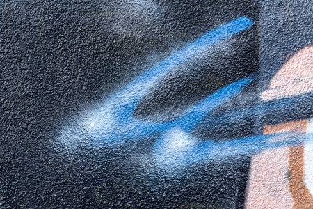 Detail of a graffiti art on a wall. Wall painted in different colors. Abstract dark blue background.の写真素材