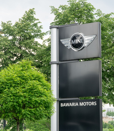 WARSAW, POLAND, May 21, 2016, 5 Red Mini Cooper with white roof mounted on the wall of the building and the car showroom. MINI Cooper is a brand of car made by BMW.のeditorial素材