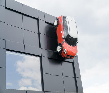 WARSAW, POLAND, May 21, 2016: Red Mini Cooper 5 with white roof  mounted on the wall of the building a car showroom. MINI Cooper is a brand of car made by BMW.のeditorial素材