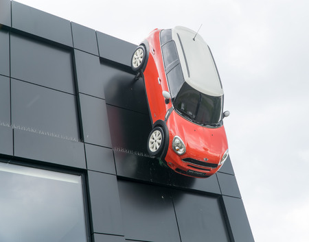WARSAW, POLAND, May 21, 2016: Red Mini Cooper 5 with white roof  mounted on the wall of the building a car showroom. MINI Cooper is a brand of car made by BMW.のeditorial素材