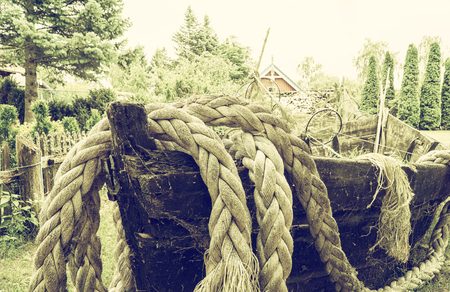 Detail of old wooden fishing boat with ropes and fishing net. Vintage filter effectの写真素材