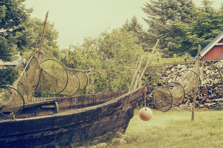 Old wooden fishing boat with drying up fishing nets. Vintage filter effectの写真素材