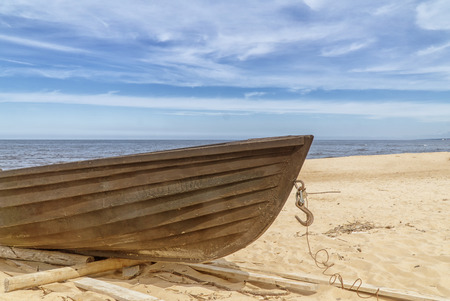 Old wooden fishing boat on beach. Blue sky with white clouds. Sunny dayの写真素材