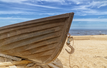 Old wooden fishing boat on beach. Blue sky with white clouds. Sunny dayの写真素材