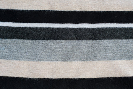 Knitwear striped in grey, black, beige, white. Textured background.の写真素材