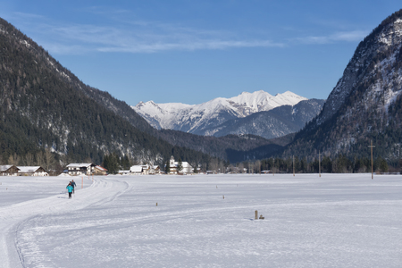 Winter mountains landscape with groomed ski track and blue sky in sunny dayの写真素材