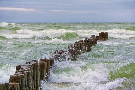 Wooden breakwater in the stormy sea. Seascape, Baltic sea near Klaipeda, Lithuania.の写真素材