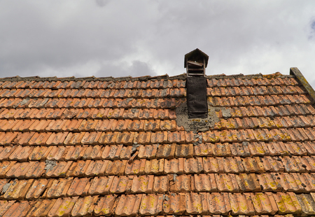 Ceramic tiles on roof of old hut with tin chimneyの写真素材
