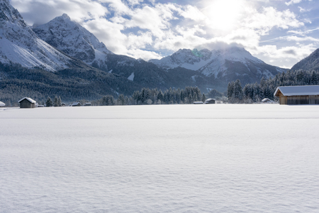 Winter mountain landscape with valley covered of fresh snow and blue sky with white clouds in sunny day. Ehrwald valley, Tirol, Alps, Austria.の写真素材
