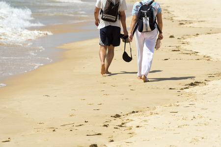 Couple walking on the beach in the summer sunny day.の写真素材