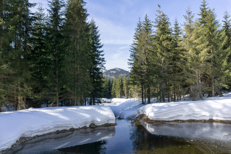 Winter mountain landscape with stream surroundings of Jakuszyce, Poland. View on Bukovec  peak in Jizera Mountains.の写真素材