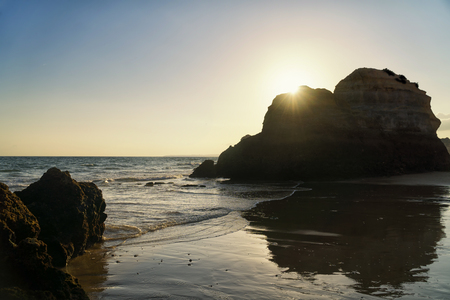 Sunset over the rock formations on a Praia da Rocha in Portimao, Algarve region, Portugal.の写真素材