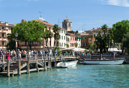Sirmione, Italy -  August 07 2017: Tourists are waiting for a ship in the port of Sirmione on Lake Garda. Sirmione is medieval town located on the Sirmio peninsula of Lake Garda, Ital, Europe.のeditorial素材
