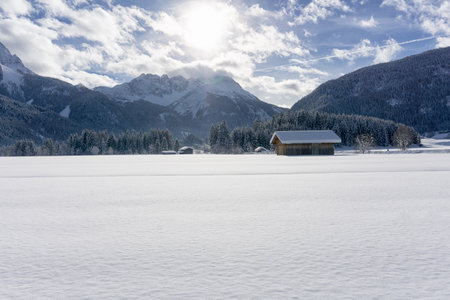 Winter mountain landscape with valley covered of fresh snow and blue sky with white clouds in sunny day. Ehrwald valley, Tirol, Alps, Austria.の写真素材