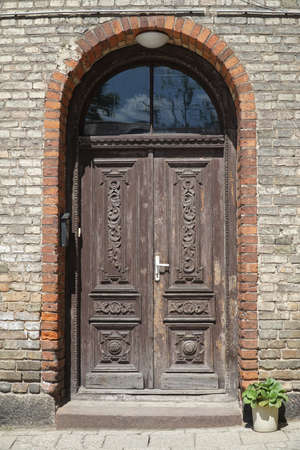 Old wooden carved double door, brick building entrance. Bialystok, Poland, Europe.の写真素材