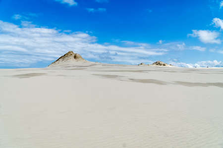 Lacka dune in Slowinski National Park in Poland, a miracle of nature. Traveling dune in sunny summer day. Sandy beach and blue sky with white clouds.の写真素材