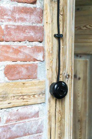 Vintage electrical switch, light button with black electric cable mounted on a half-timbered or timber-framed wall.の写真素材