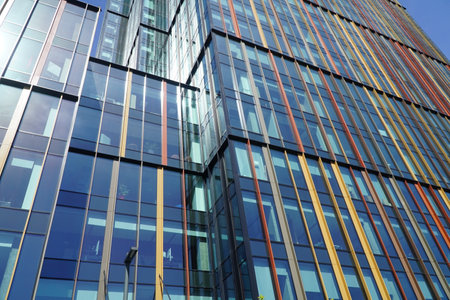Modern office building exterior with glass and steel facade on clear sky background. Transparent glass wall of office building with color decoration. Element of facade of modern business building.の写真素材
