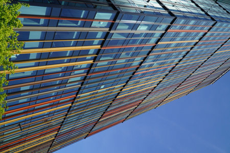 Modern office building exterior with glass and steel facade on clear sky background. Transparent glass wall of office building with color decoration. Element of facade of modern business building.の写真素材